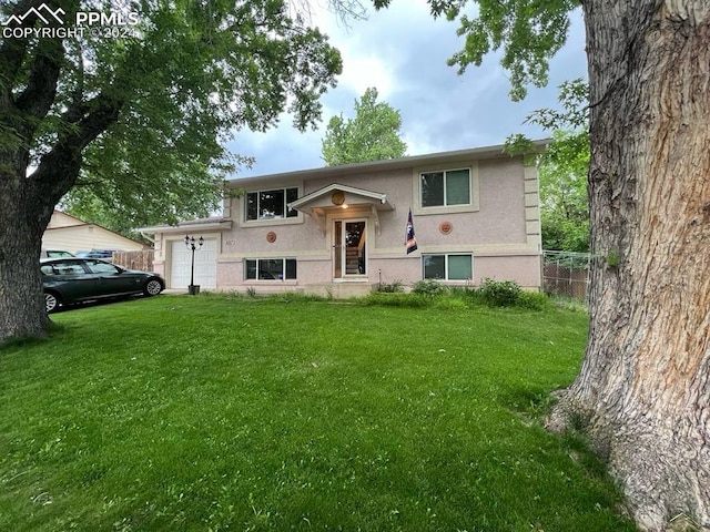 raised ranch with a garage and a front yard