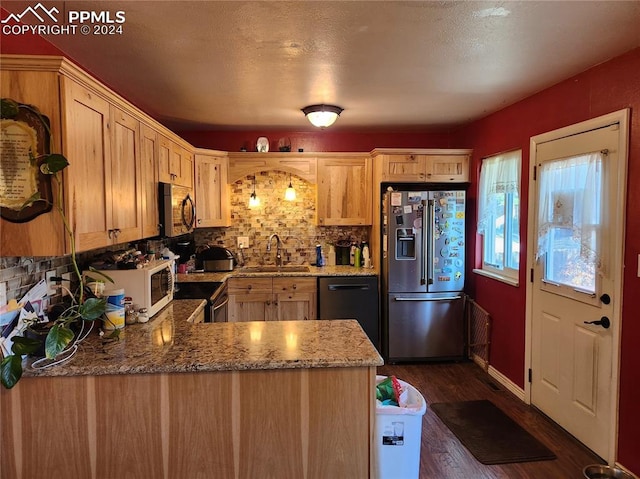 kitchen featuring light brown cabinets, dark wood-type flooring, sink, kitchen peninsula, and stainless steel appliances