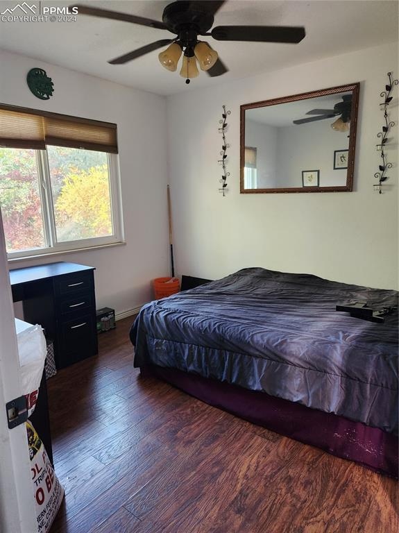 bedroom with ceiling fan and dark wood-type flooring