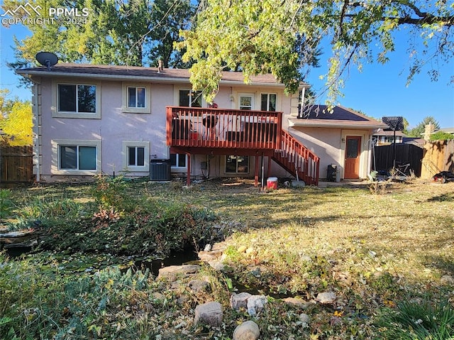 back of property featuring a lawn, central AC unit, and a wooden deck