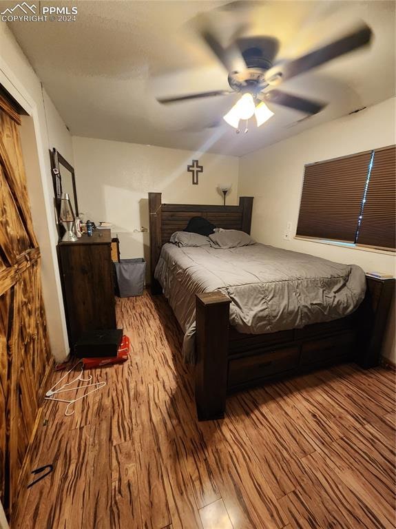 bedroom with light hardwood / wood-style floors and ceiling fan