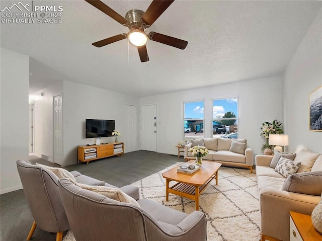 living room with a textured ceiling and ceiling fan