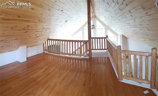 bonus room with lofted ceiling with beams and wood-type flooring