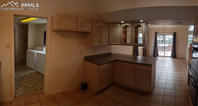 kitchen with kitchen peninsula, light brown cabinetry, tile patterned floors, an inviting chandelier, and washing machine and dryer