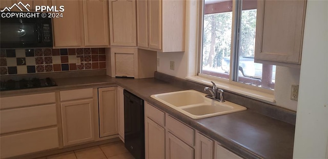 kitchen with light tile patterned floors, sink, a healthy amount of sunlight, and black appliances