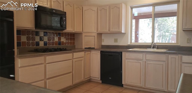 kitchen with decorative backsplash, sink, light tile patterned floors, and black appliances