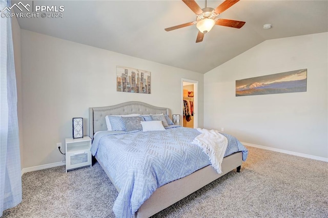 carpeted bedroom with a closet, a walk in closet, lofted ceiling, and ceiling fan