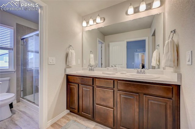 bathroom featuring vanity, toilet, and a shower with door