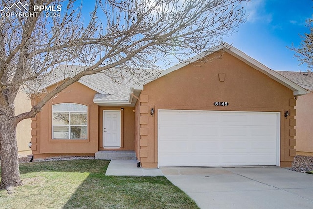 single story home featuring a garage and a front yard