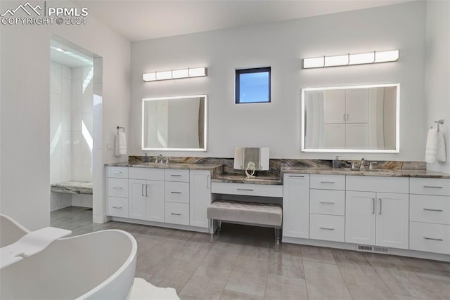 full bathroom with two vanities, visible vents, a sink, and a freestanding bath