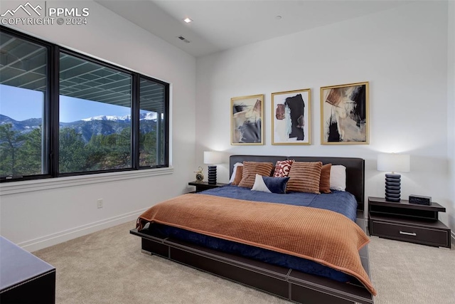 bedroom with carpet floors, visible vents, baseboards, and a mountain view