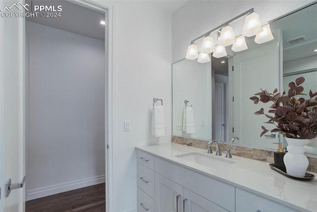 bathroom featuring wood finished floors, vanity, visible vents, and baseboards