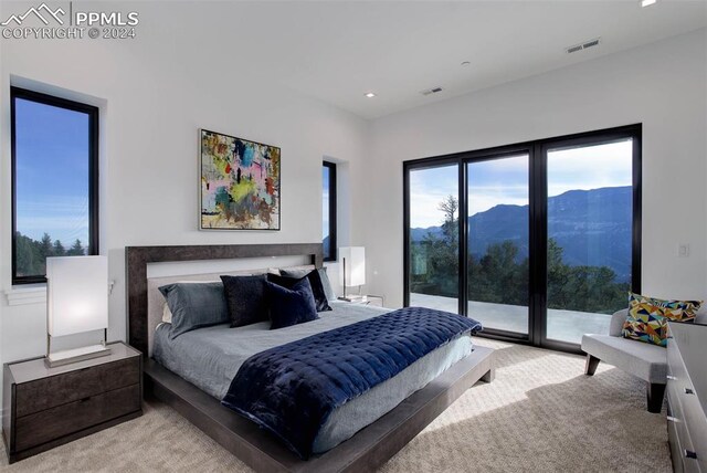 bedroom with access to exterior, visible vents, and light colored carpet