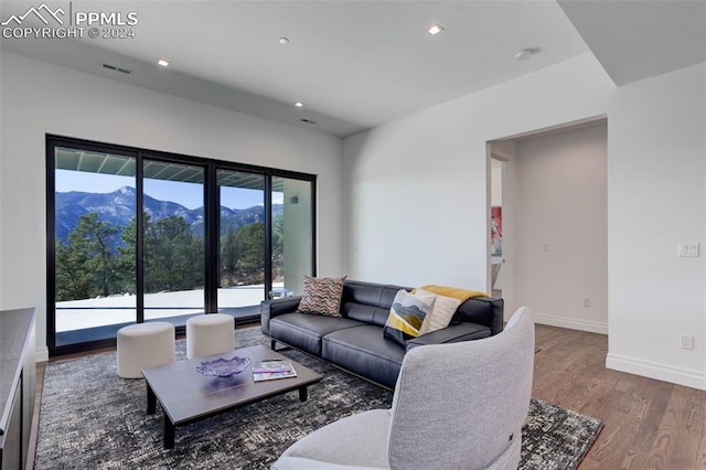 living room featuring baseboards, visible vents, wood finished floors, a mountain view, and recessed lighting