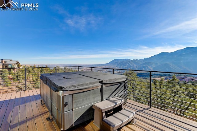 wooden deck featuring a hot tub and a mountain view