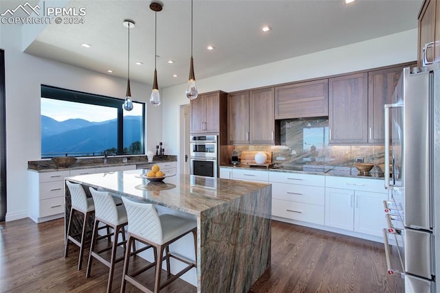 kitchen with dark wood-style floors, a kitchen island, stainless steel appliances, and decorative backsplash