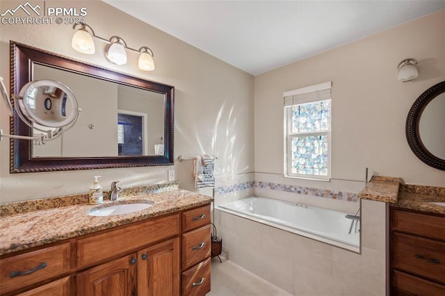 bathroom with vanity and tiled bath