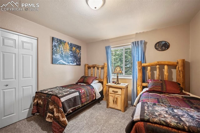 bedroom featuring a closet, a textured ceiling, and light carpet