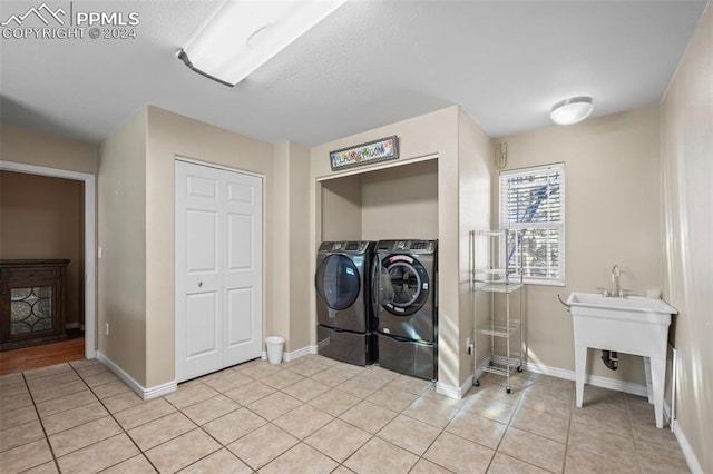 laundry area with light tile patterned flooring and separate washer and dryer