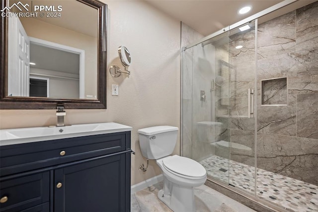 bathroom featuring walk in shower, vanity, and toilet