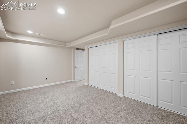 unfurnished bedroom with carpet and multiple closets