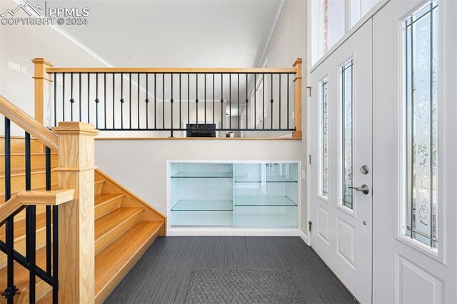 foyer featuring a wealth of natural light and crown molding