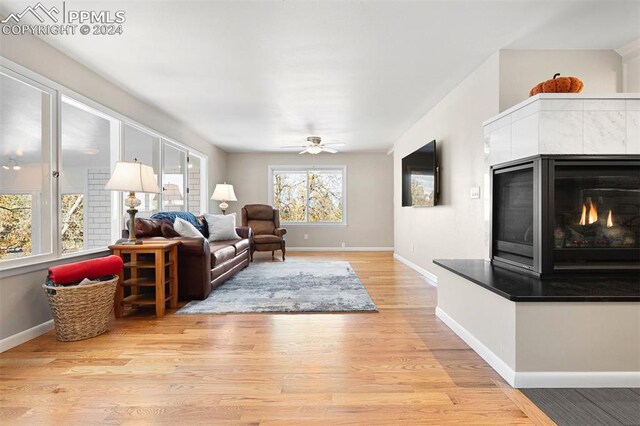 living room with light hardwood / wood-style floors and ceiling fan