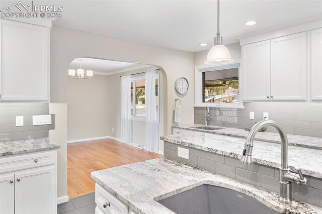 kitchen featuring white cabinets, sink, light hardwood / wood-style flooring, and decorative backsplash