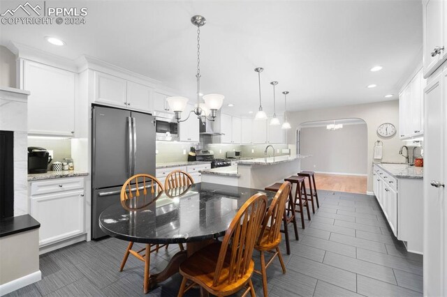 dining area featuring sink, a notable chandelier, dark hardwood / wood-style floors, and a fireplace