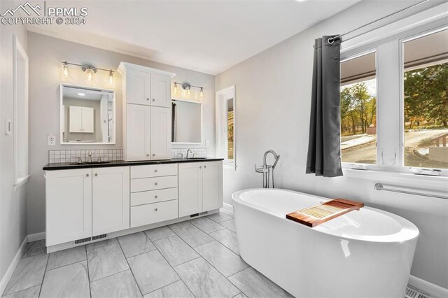 bathroom featuring vanity, a washtub, and tasteful backsplash