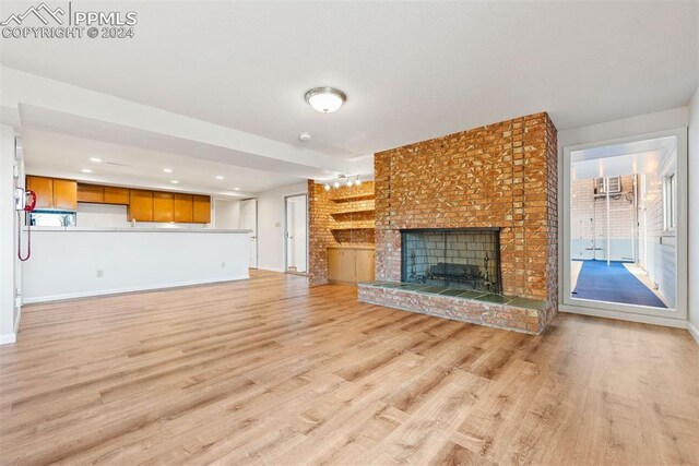 unfurnished living room featuring light wood-type flooring and a fireplace