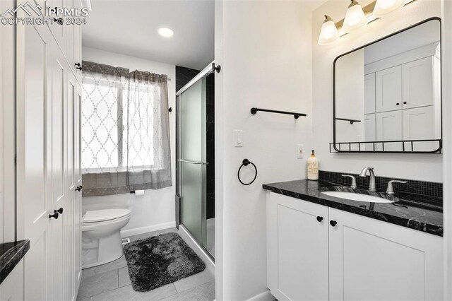 bathroom featuring tile patterned flooring, an enclosed shower, vanity, and toilet