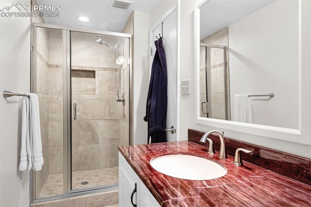 bathroom featuring vanity and a shower with door