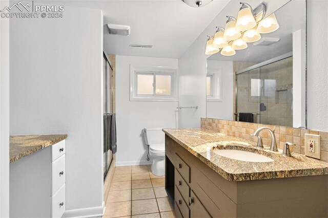 bathroom featuring walk in shower, tile patterned flooring, tasteful backsplash, vanity, and toilet