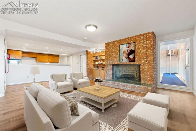 living room with light hardwood / wood-style floors and a fireplace