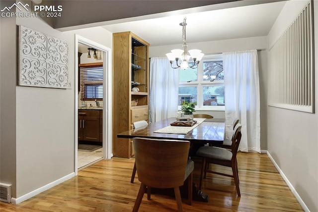 dining area featuring light hardwood / wood-style flooring and a chandelier