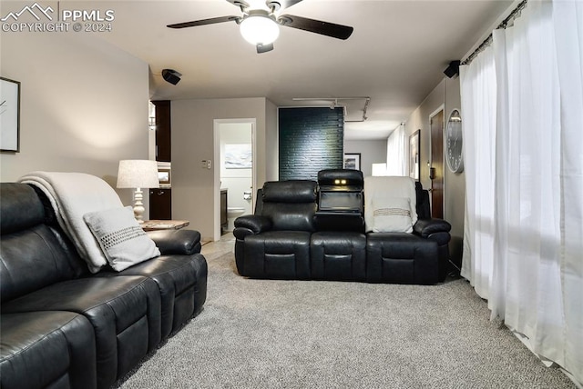 carpeted cinema room with ceiling fan