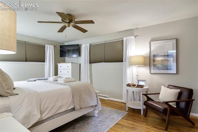 bedroom with hardwood / wood-style floors, ceiling fan, and a baseboard radiator