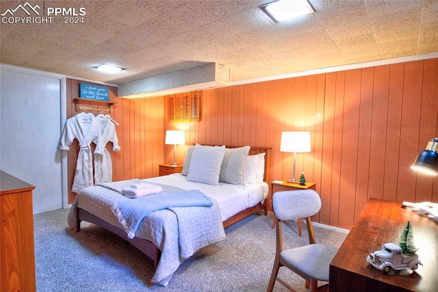 bedroom featuring wood walls and carpet flooring