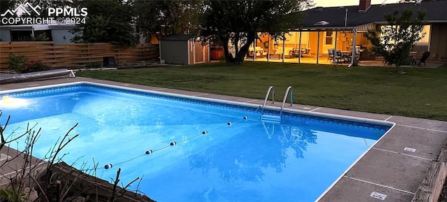 view of pool featuring a storage shed, a yard, and a patio area