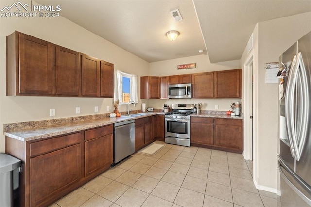 kitchen featuring appliances with stainless steel finishes, sink, and light tile patterned flooring