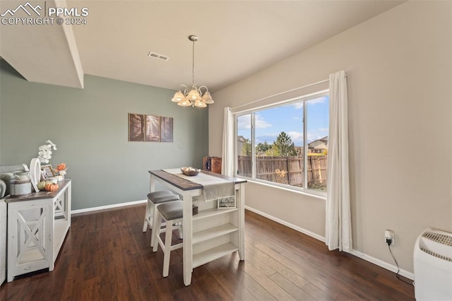 dining space featuring dark hardwood / wood-style floors and an inviting chandelier