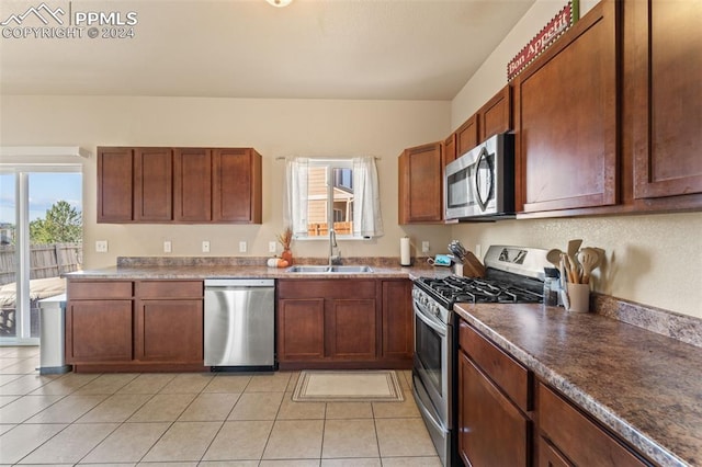 kitchen with sink, light tile patterned floors, a healthy amount of sunlight, and stainless steel appliances