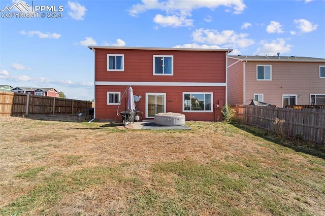 back of house featuring a patio area and a lawn