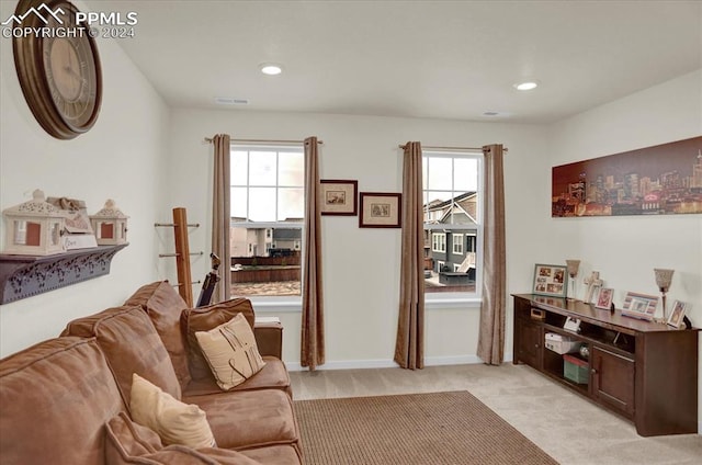 living room featuring a wealth of natural light and light colored carpet