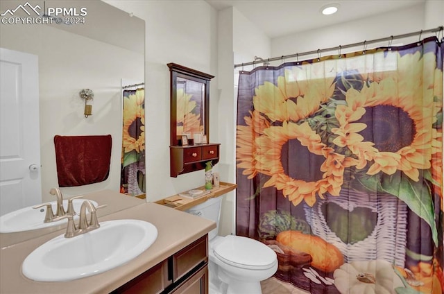 bathroom featuring walk in shower, vanity, and toilet