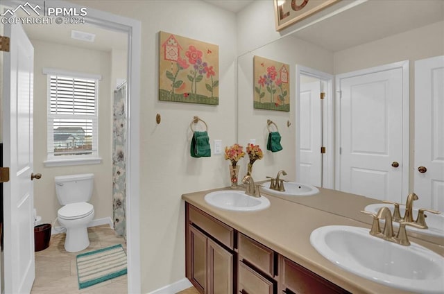 bathroom featuring toilet, vanity, and tile patterned flooring