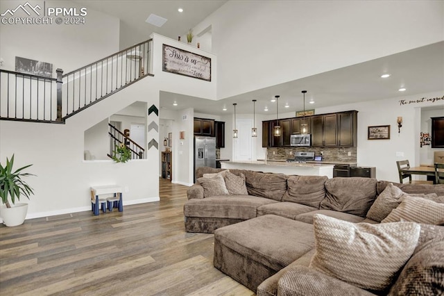 living room with a high ceiling and light wood-type flooring