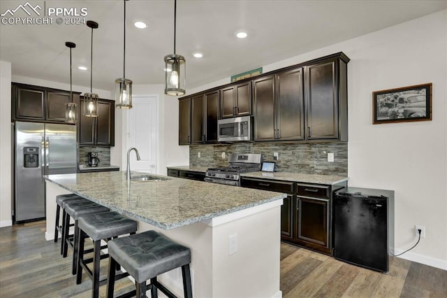 kitchen with stainless steel appliances, sink, decorative light fixtures, and backsplash