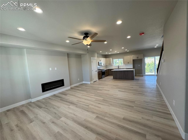 unfurnished living room with wood-type flooring and ceiling fan